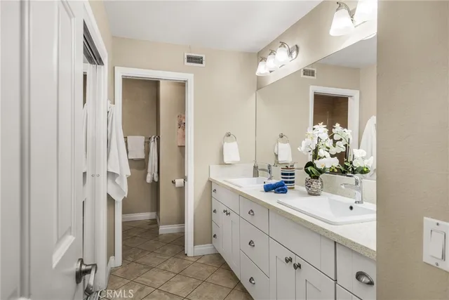 a bathroom with a double vanity sink mirror and shower