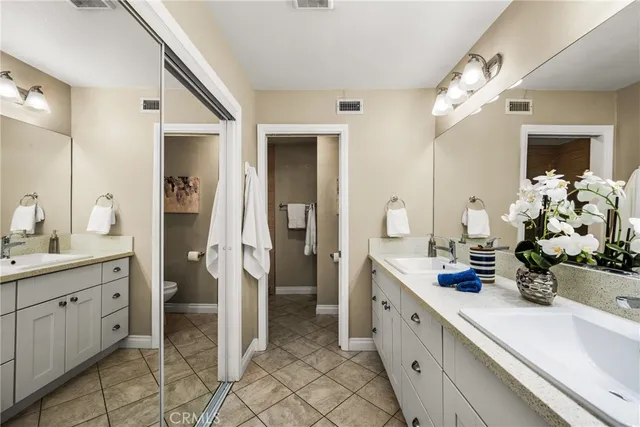 a spacious en suite bathroom with double sink and a mirror
