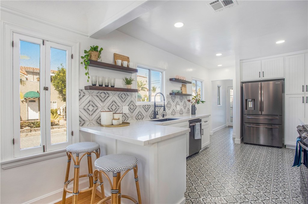 134 Prospect Avenue Long Beach, CA 90803 - Photo 11 of 21 a kitchen with stainless steel appliances kitchen island granite countertop a refrigerator and a stove top oven