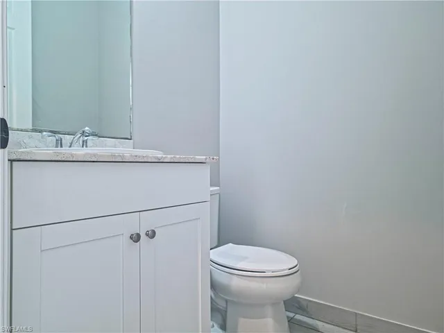 a bathroom with a sink a toilet and mirror