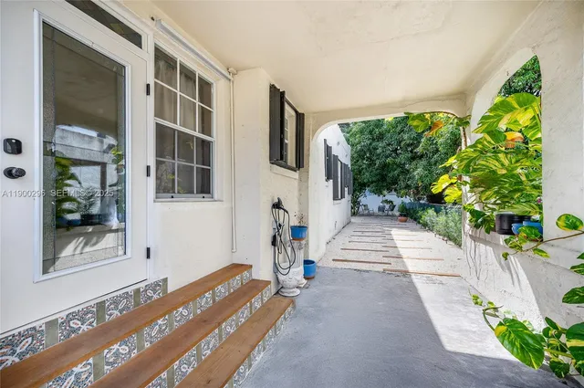 a front view of a house with a yard and potted plants
