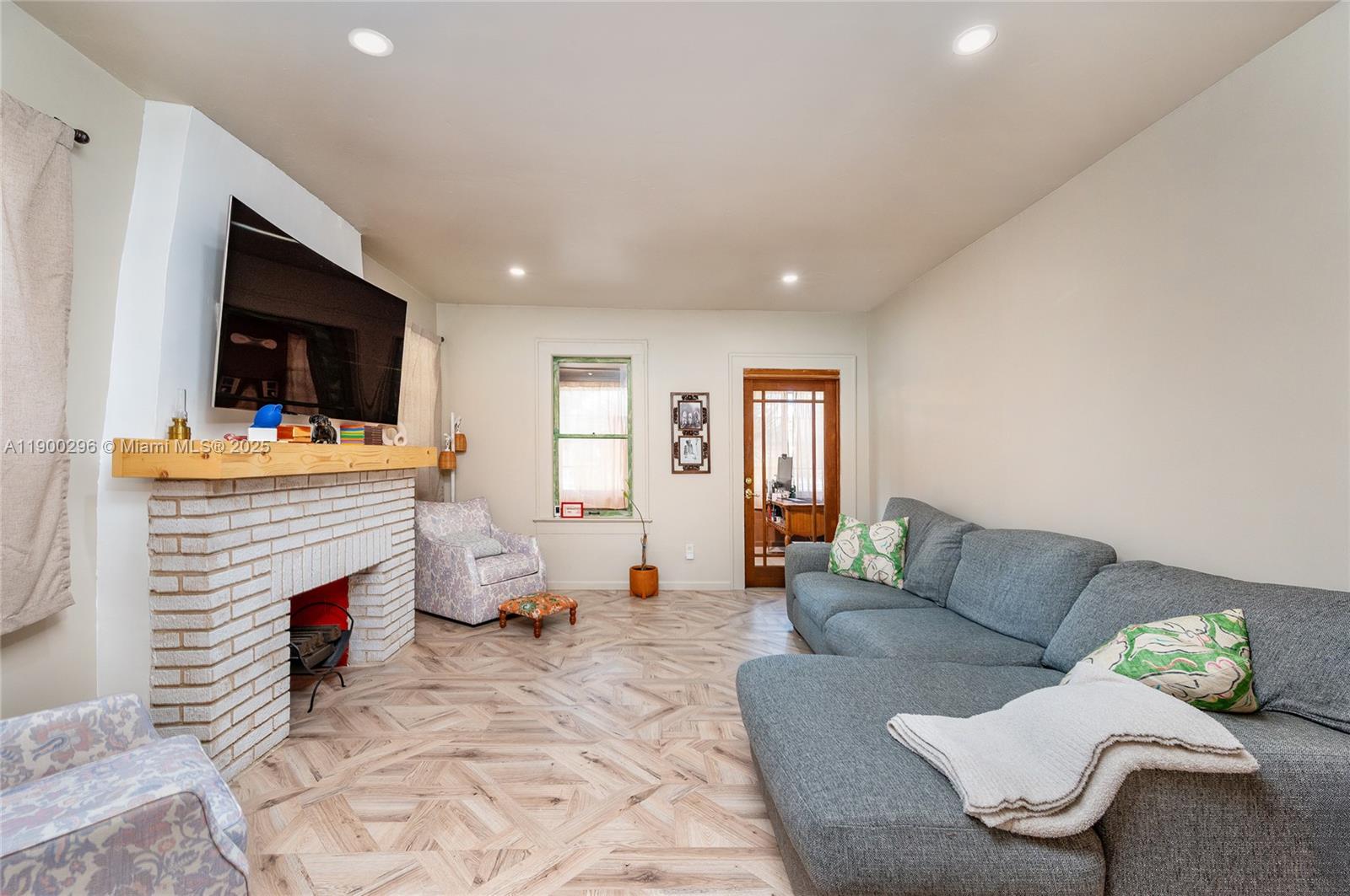 1844 Northwest 47th Street Miami, FL 33142 - Photo 5 of 24 a living room with furniture a flat screen tv and a fireplace
