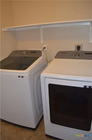a view of an empty room with a chandelier fan