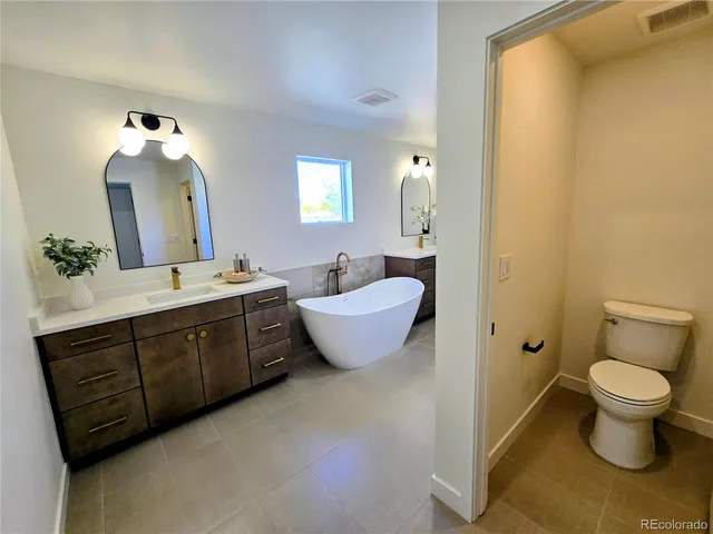 a bathroom with a double vanity sink toilet and a mirror
