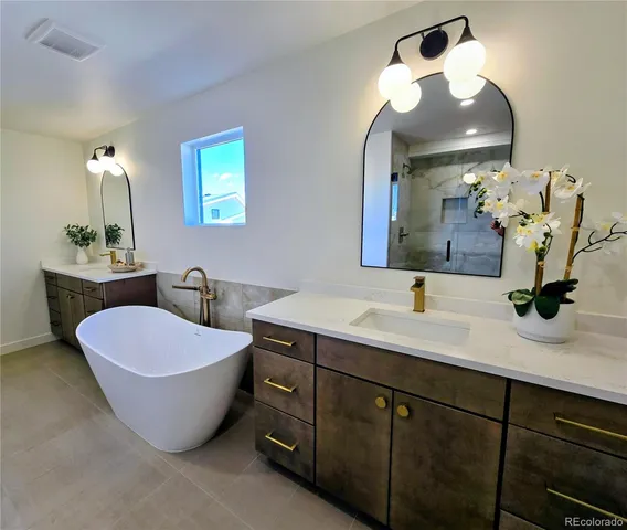 a spacious bathroom with a double vanity sink mirror and bathtub