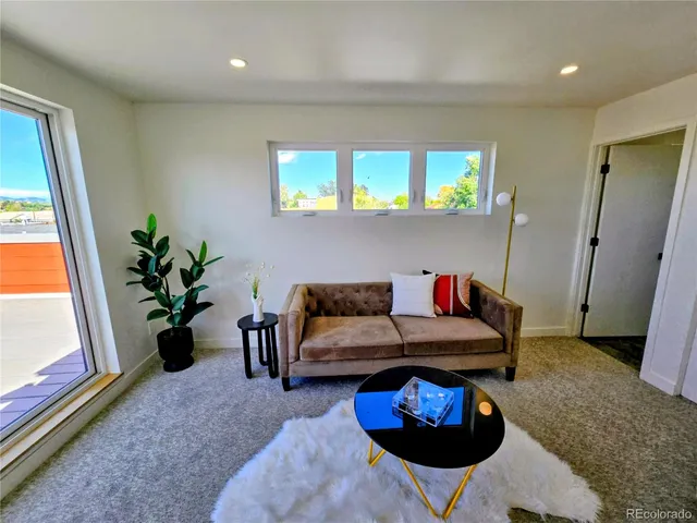 a living room with furniture and a potted plant