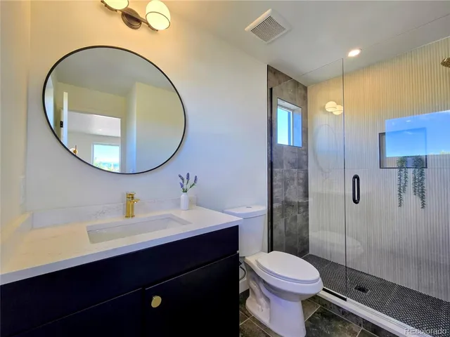 a bathroom with a sink a toilet and a mirror