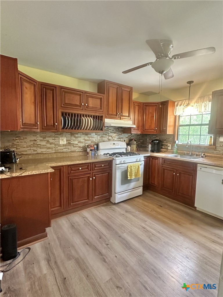 2006 Meadowlane Street Victoria, TX 77901 - Photo 4 of 15 a kitchen with stainless steel appliances granite countertop wooden cabinets a sink a stove a refrigerator with grey cabinets