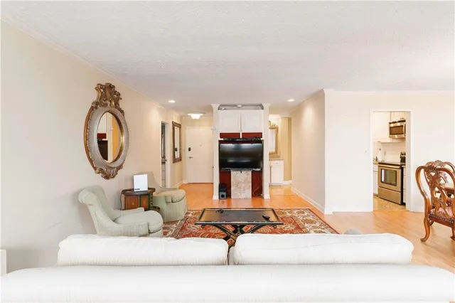 a living room with furniture a mirror and a chandelier