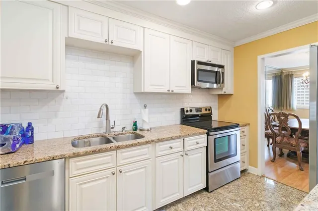a kitchen with stainless steel appliances granite countertop a sink stove and cabinets