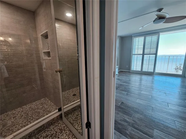a bathroom with a glass shower door and a window