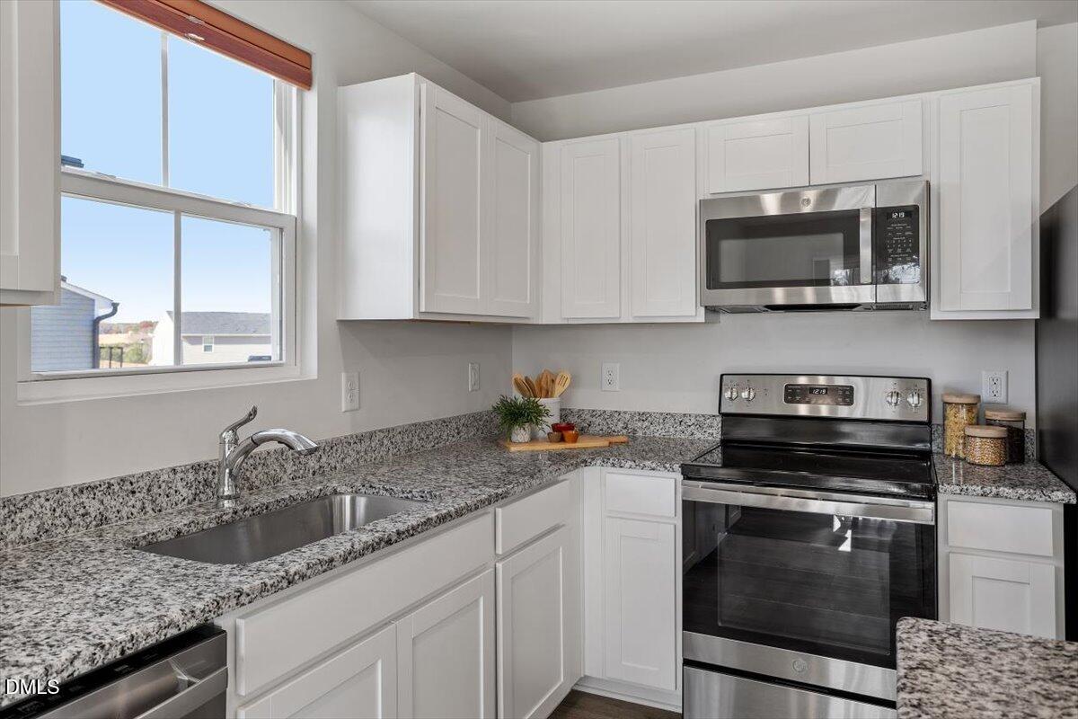 278 Hunting Wood Drive Angier, NC 27501 - Photo 23 of 36 a kitchen with granite countertop a sink stove and microwave