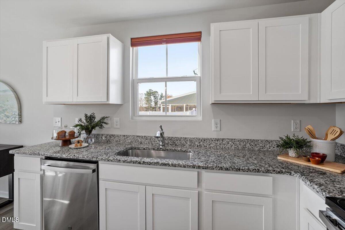 278 Hunting Wood Drive Angier, NC 27501 - Photo 26 of 36 a kitchen with stainless steel appliances granite countertop white cabinets sink and window