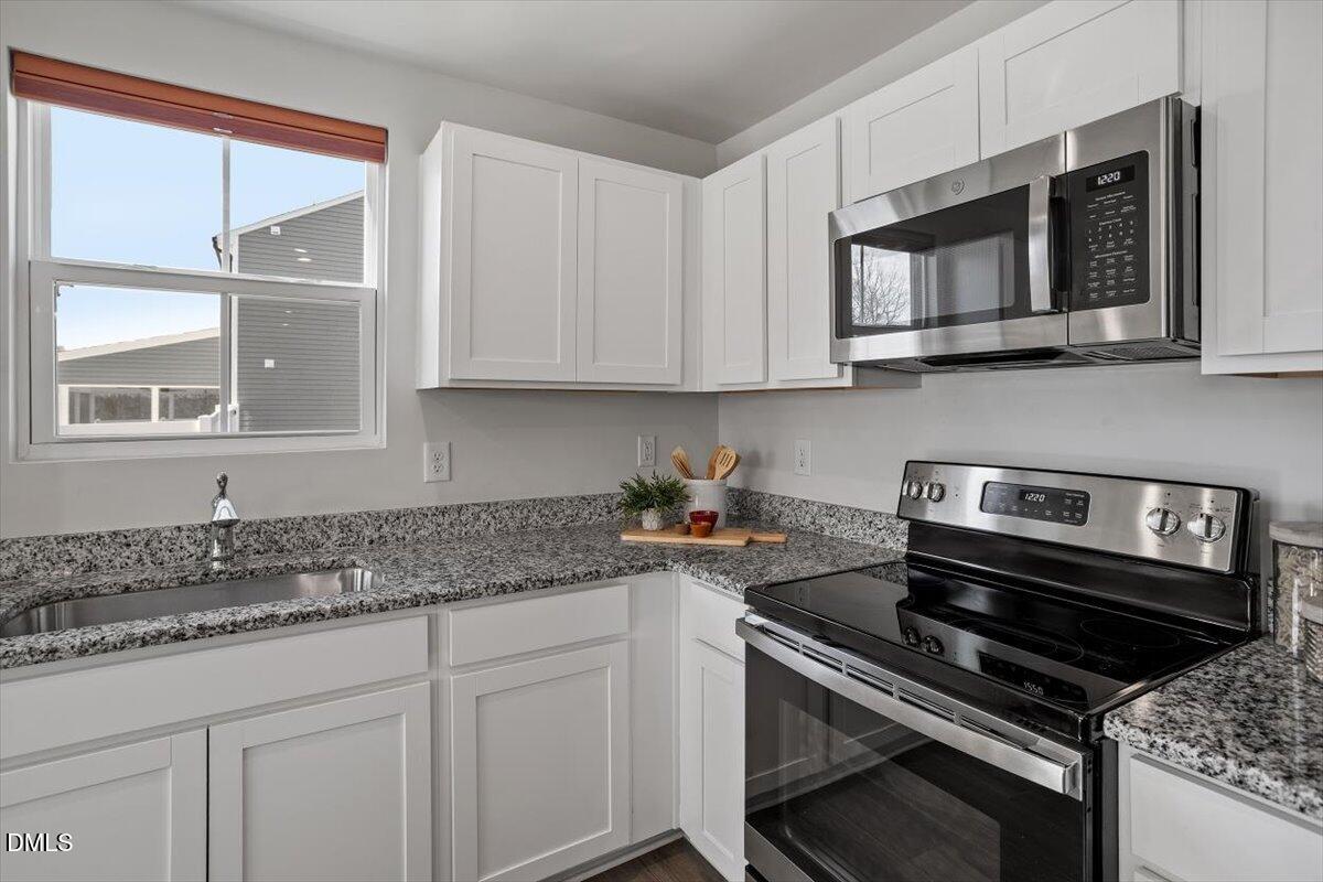 278 Hunting Wood Drive Angier, NC 27501 - Photo 27 of 36 a kitchen with stainless steel appliances granite countertop a sink stove and microwave