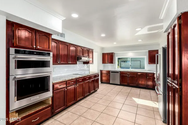 a large kitchen with stainless steel appliances granite countertop a large stove top oven and cabinets