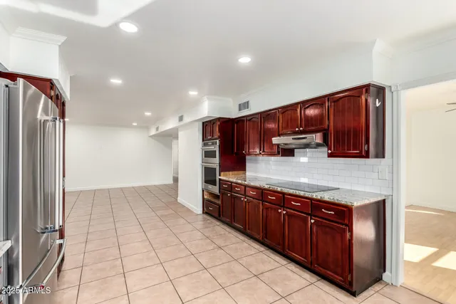 a kitchen with stainless steel appliances granite countertop a stove a refrigerator and a oven