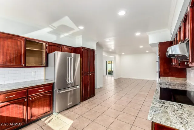 a kitchen with stainless steel appliances granite countertop a refrigerator and a sink
