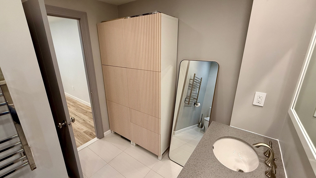 1206 Greendale Avenue, Unit 201 Needham, MA 02492 - Photo 29 of 39 a bathroom with a sink a mirror and a shower