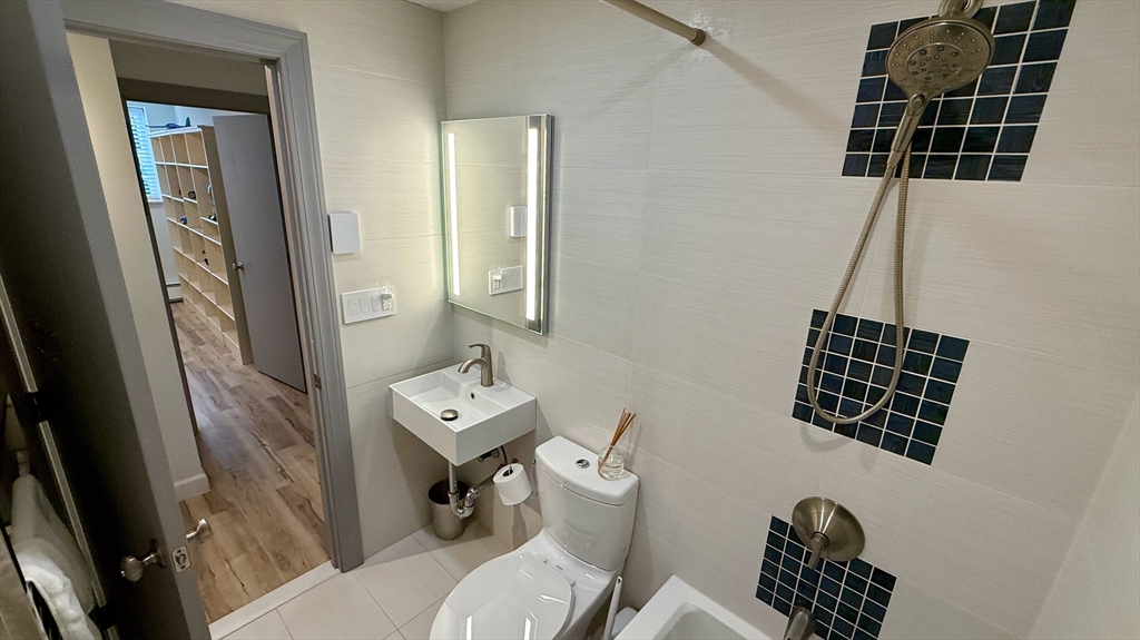 1206 Greendale Avenue, Unit 201 Needham, MA 02492 - Photo 34 of 39 a bathroom with a toilet a sink and a mirror