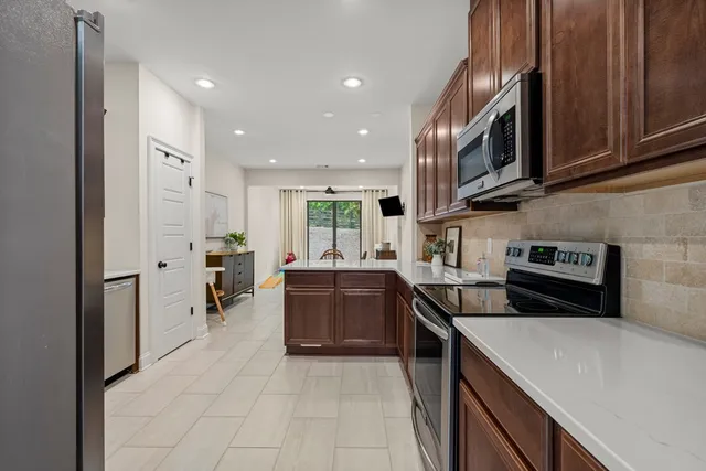 a kitchen with stainless steel appliances granite countertop a refrigerator and a sink