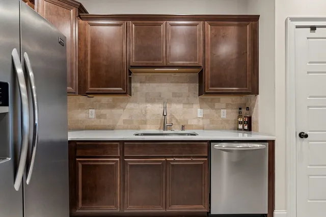 a kitchen with kitchen island a refrigerator stove microwave and sink