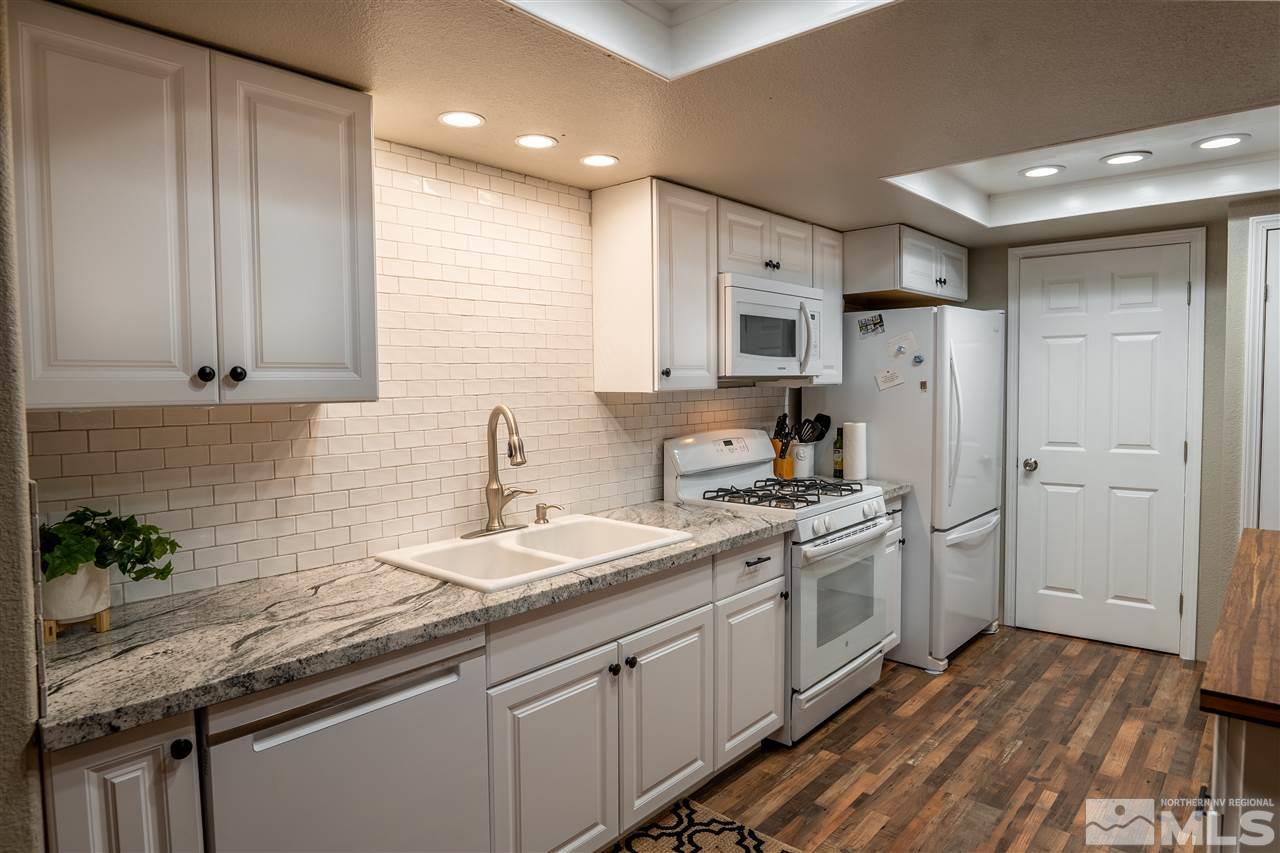 9335 Fremont Way Reno, NV 89506 - Photo 2 of 16 a kitchen with stainless steel appliances granite countertop a sink stove and refrigerator