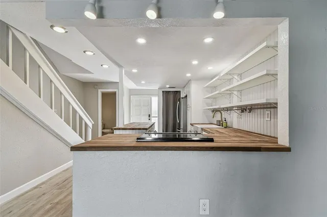 an empty room with wooden floor fireplace and windows