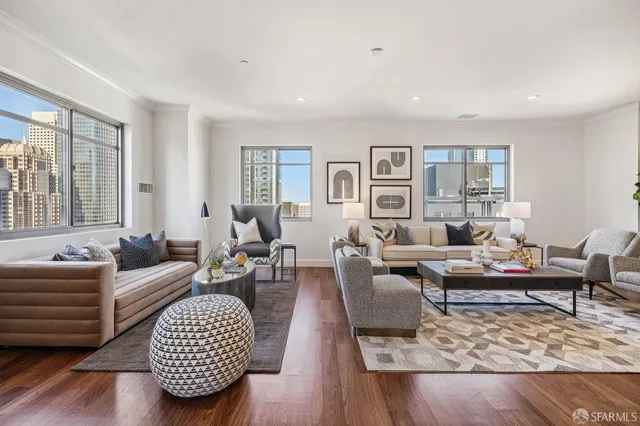 a living room with furniture large window and wooden floor