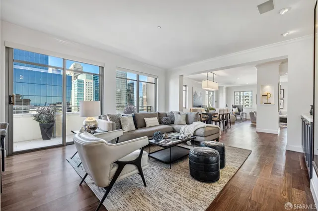 a living room with furniture a wooden floor and a large window