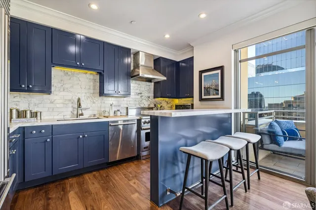 a kitchen with stainless steel appliances kitchen island granite countertop wooden floors and wooden cabinets