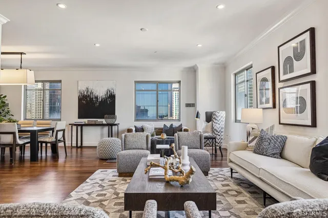 a living room with furniture large window and wooden floor