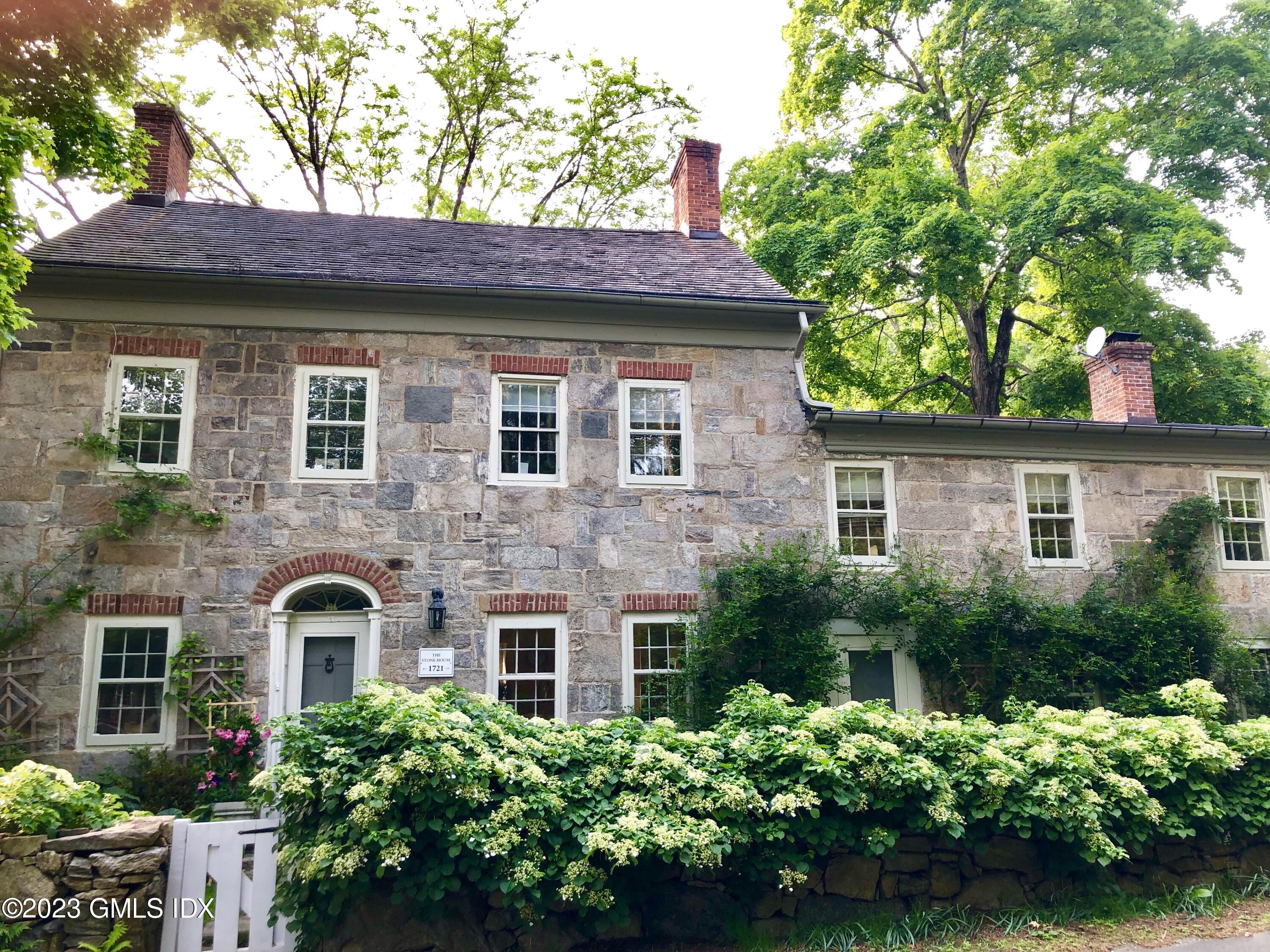 207 Farms Road Stamford, CT 06903 - Photo 2 of 47 a front view of a house with a garden