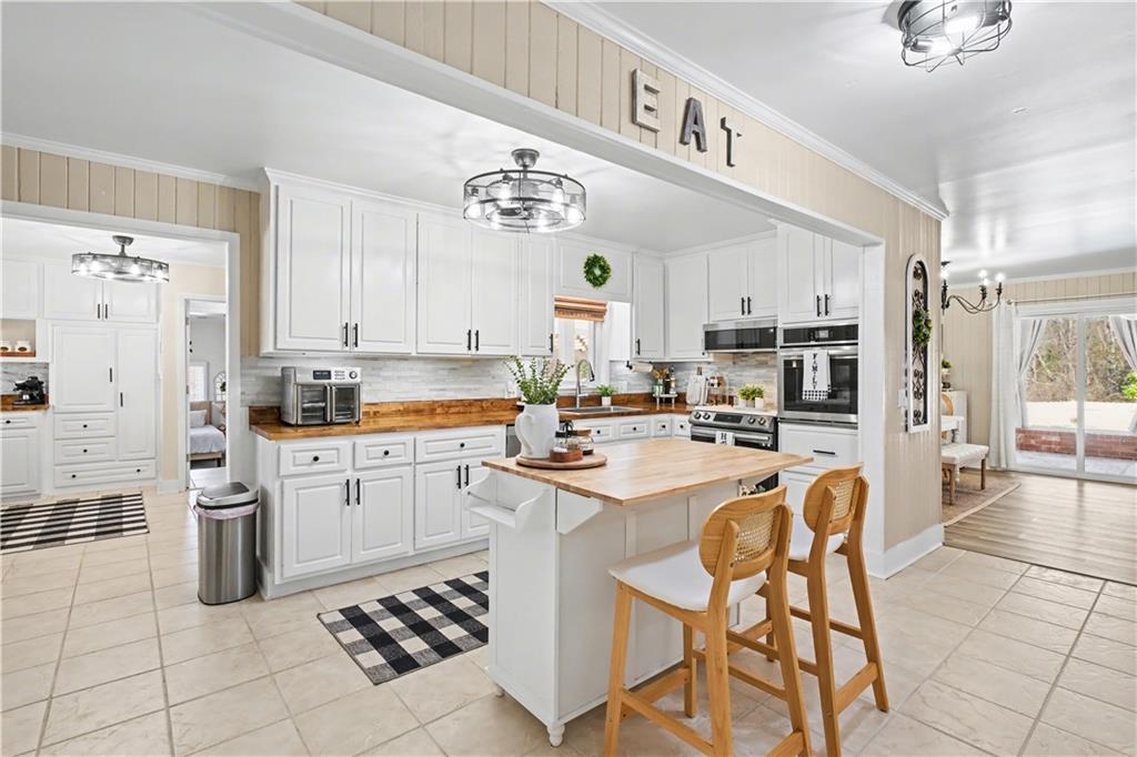 1833 Tom Odum Road Vidalia, GA 30474 - Photo 15 of 59 a kitchen with stainless steel appliances a refrigerator a stove a sink dishwasher and white cabinets with wooden floor