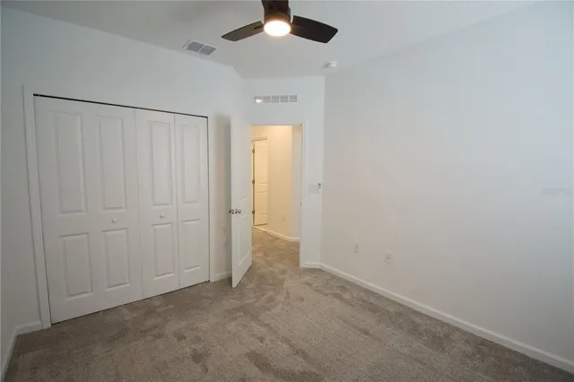 an empty room with a ceiling fan and a window