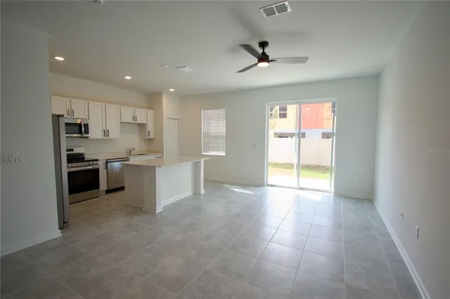 a view of a kitchen with a sink and dishwasher a refrigerator with white cabinets