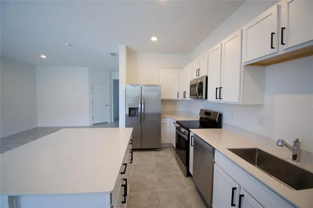 a kitchen with stainless steel appliances a refrigerator sink and microwave