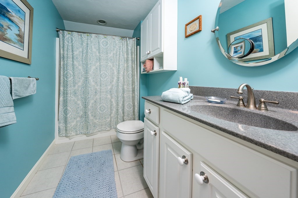17 North Ridge Road, Unit 444 Mashpee, MA 02649 - Photo 14 of 18 a bathroom with a granite countertop sink mirror vanity and toilet
