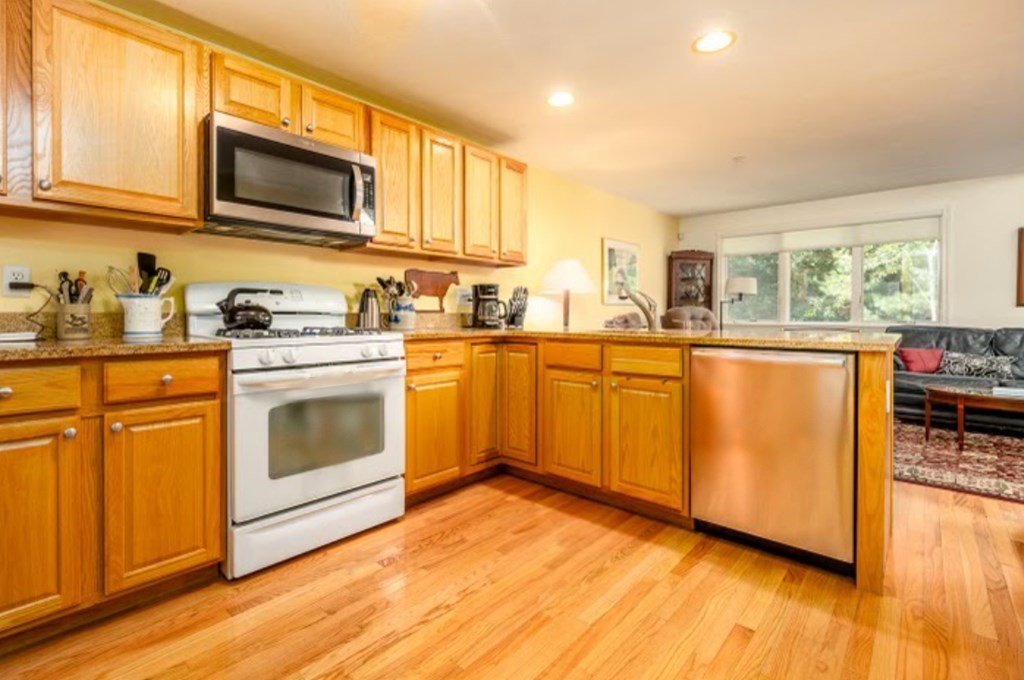 17 North Ridge Road, Unit 444 Mashpee, MA 02649 - Photo 2 of 18 a kitchen with stainless steel appliances granite countertop a stove a sink dishwasher and a microwave oven with cabinets