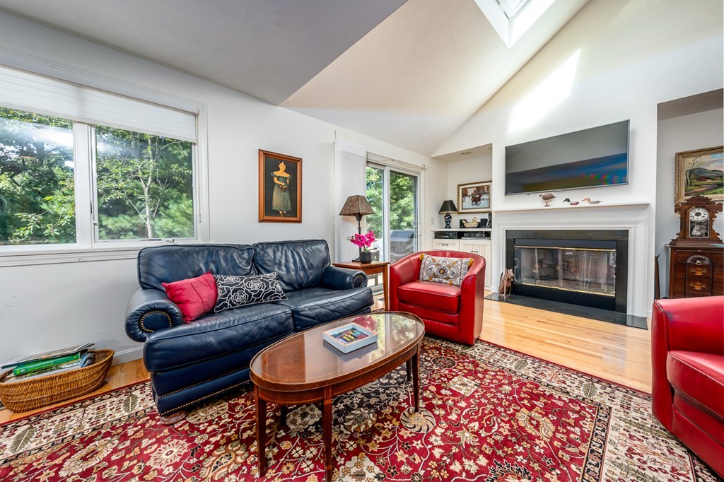 17 North Ridge Road, Unit 444 Mashpee, MA 02649 - Photo 6 of 18 a living room with furniture a flat screen tv and a fireplace
