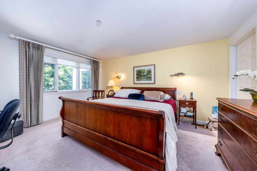 17 North Ridge Road, Unit 444 Mashpee, MA 02649 - Photo 8 of 18 a bed room with a bed and a chandelier