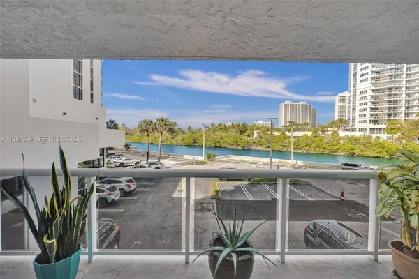 a view of a balcony with potted plants and palm trees
