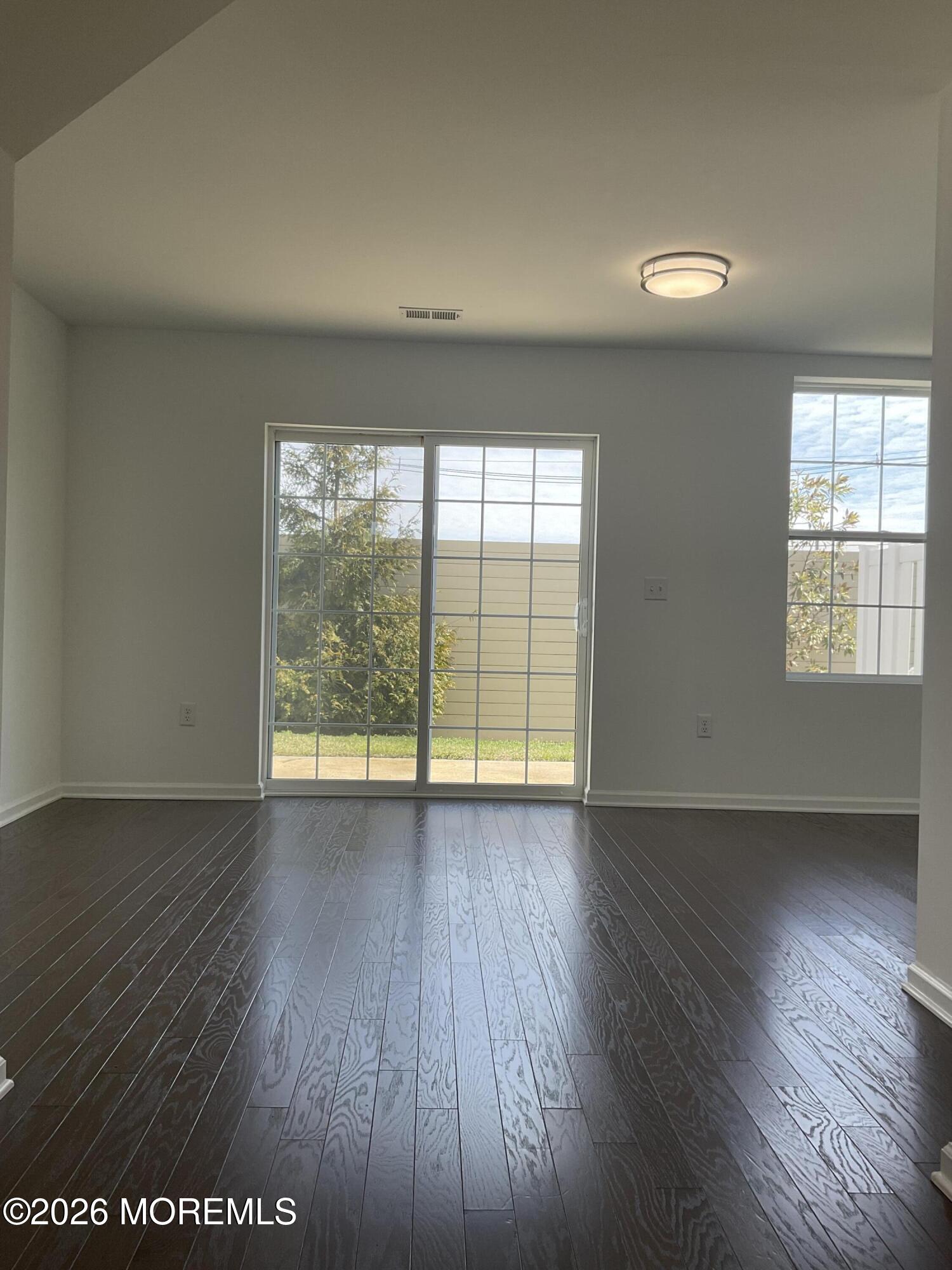 304 Prestige Road, Unit 2404 Brick, NJ 08723 - Photo 11 of 25 an empty room with wooden floor and windows