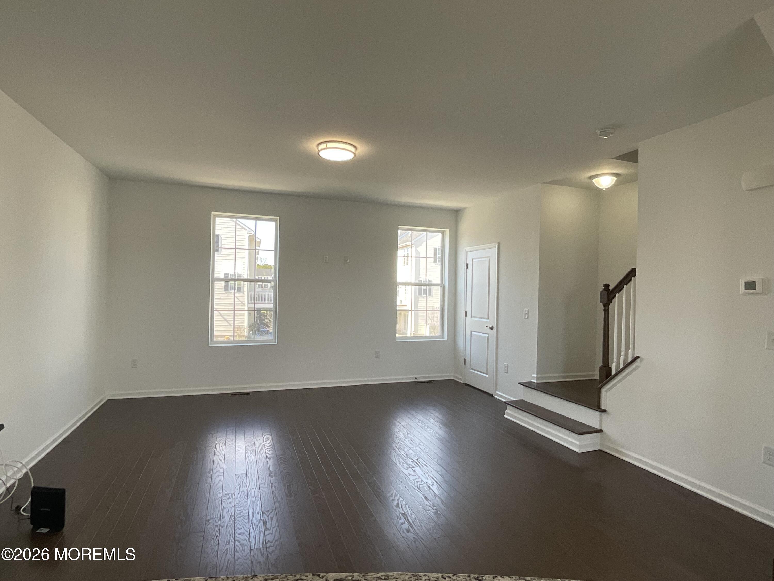 304 Prestige Road, Unit 2404 Brick, NJ 08723 - Photo 8 of 25 an empty room with wooden floor and windows with curtains