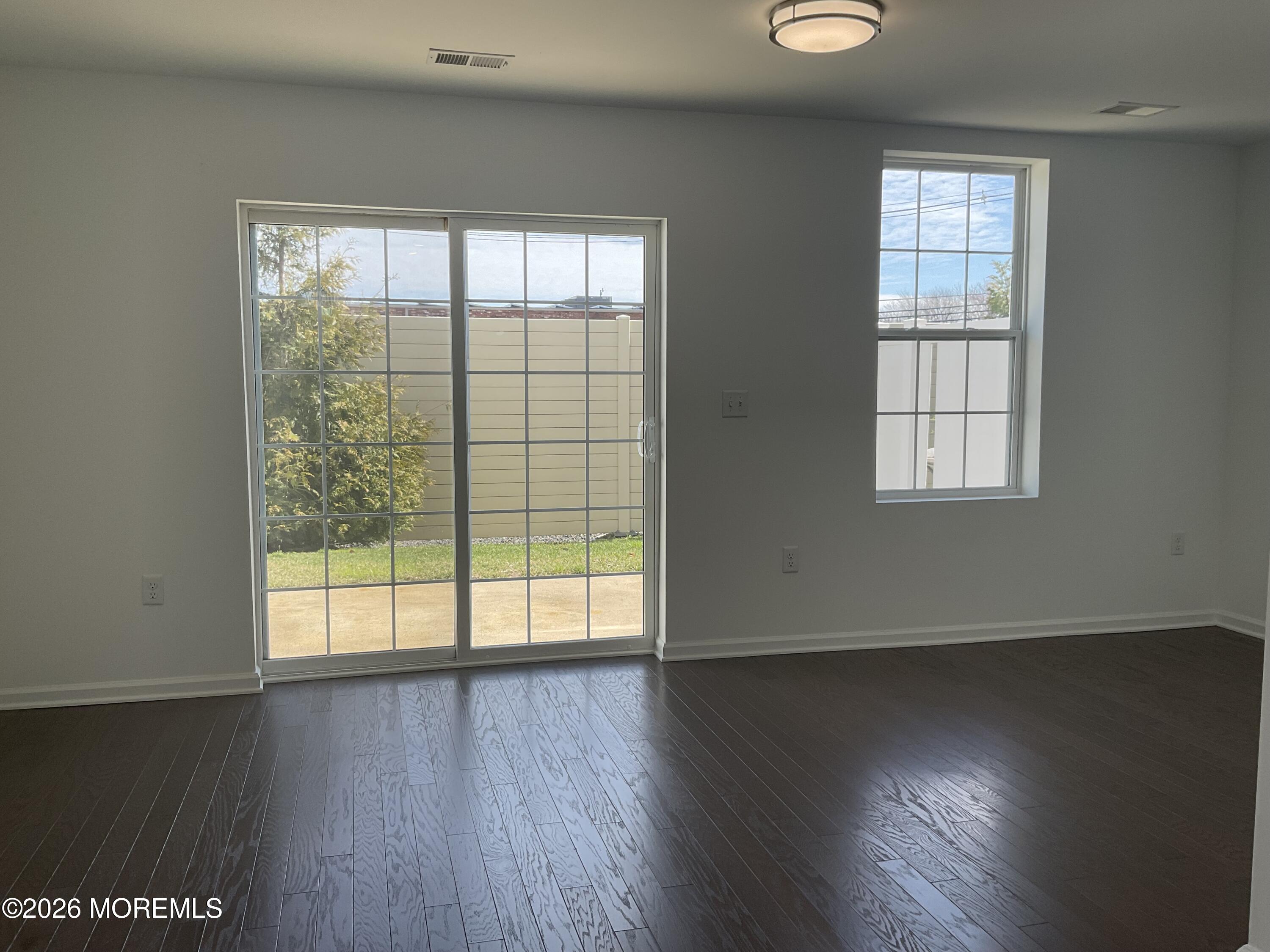 304 Prestige Road, Unit 2404 Brick, NJ 08723 - Photo 9 of 25 an empty room with wooden floor and windows