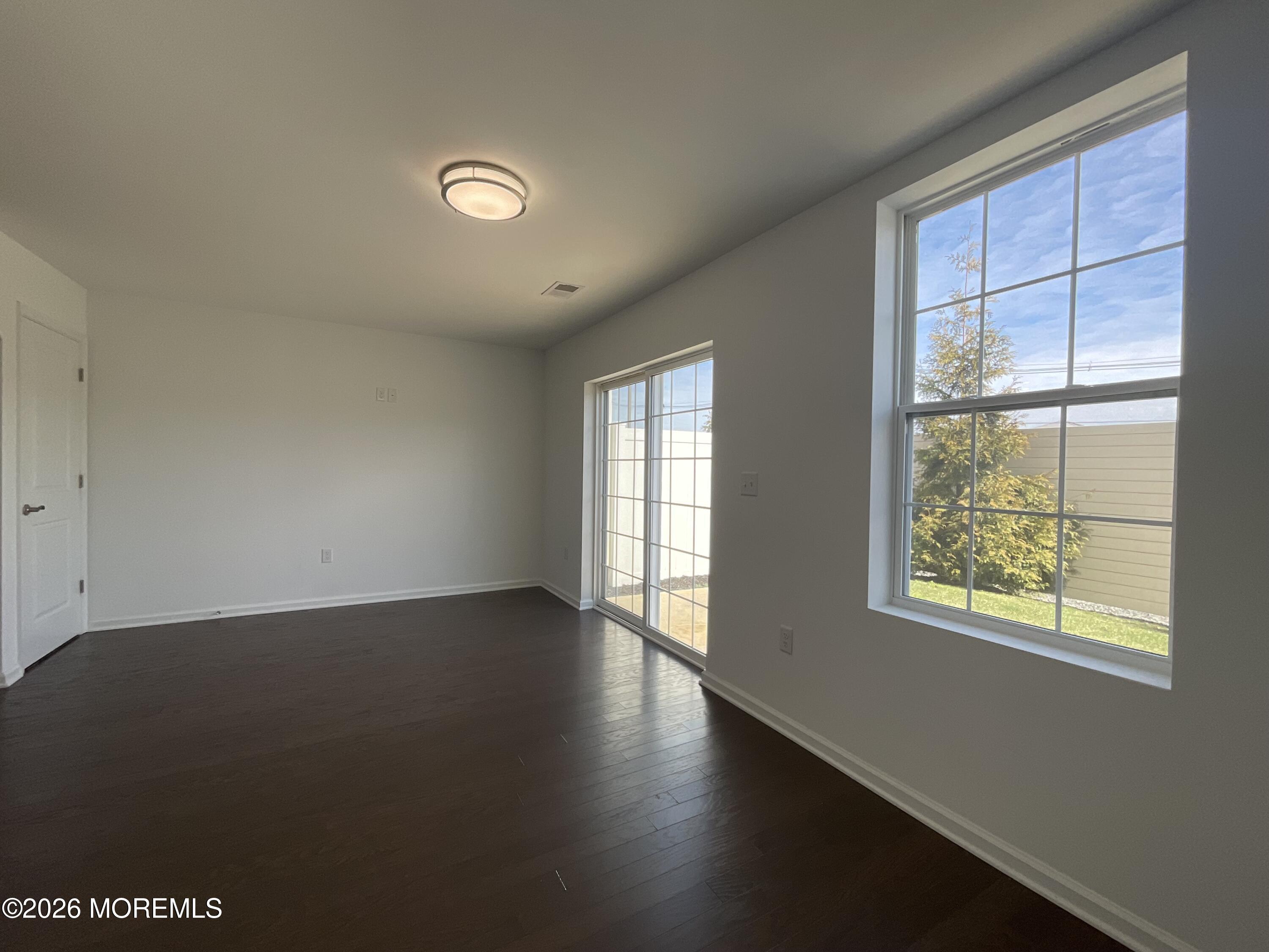 304 Prestige Road, Unit 2404 Brick, NJ 08723 - Photo 10 of 25 an empty room with wooden floor and windows