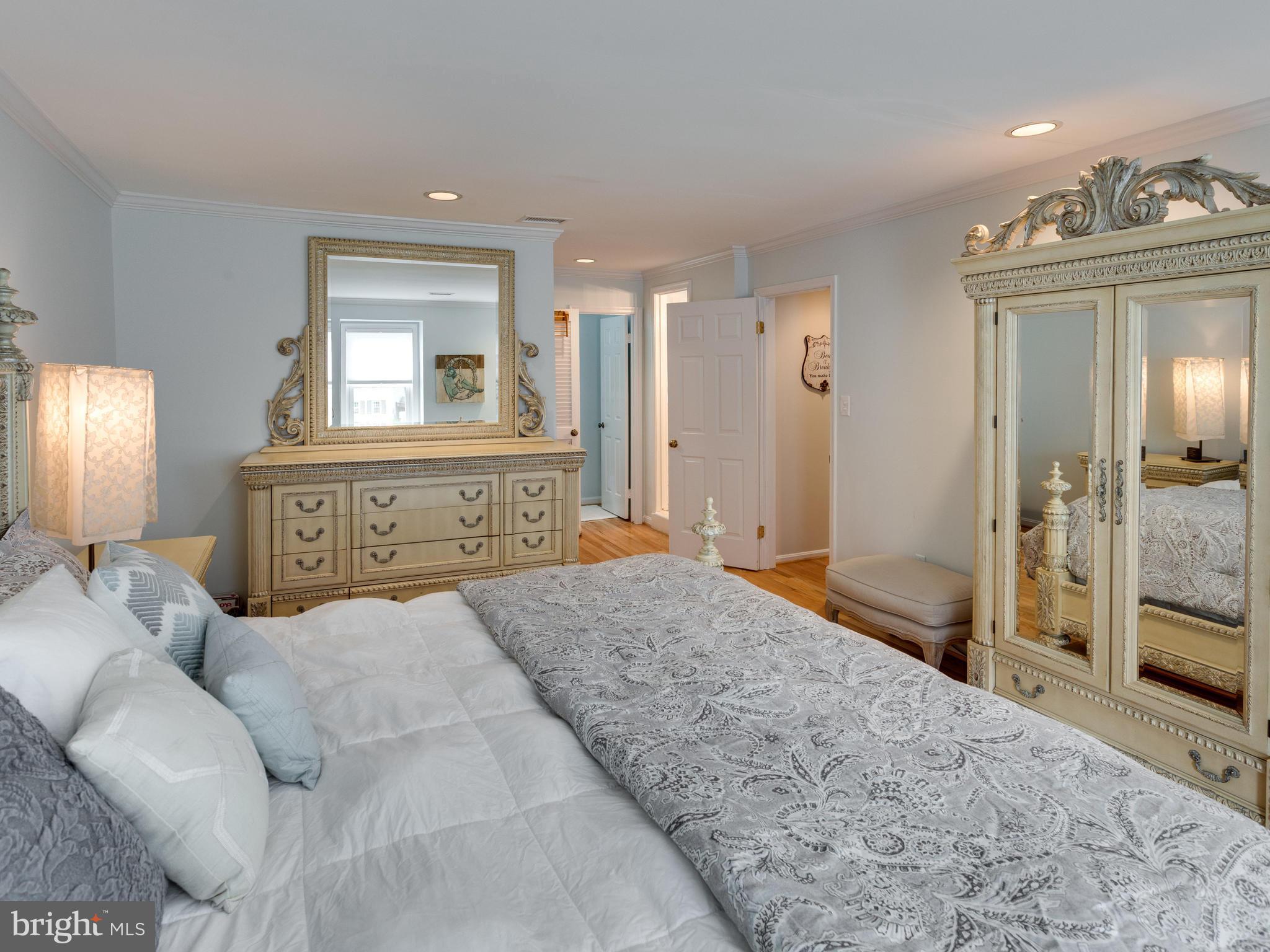 9031 Edgepark Road Vienna, VA 22182 - Photo 13 of 30 a spacious bedroom with a bed a mirror and a shower