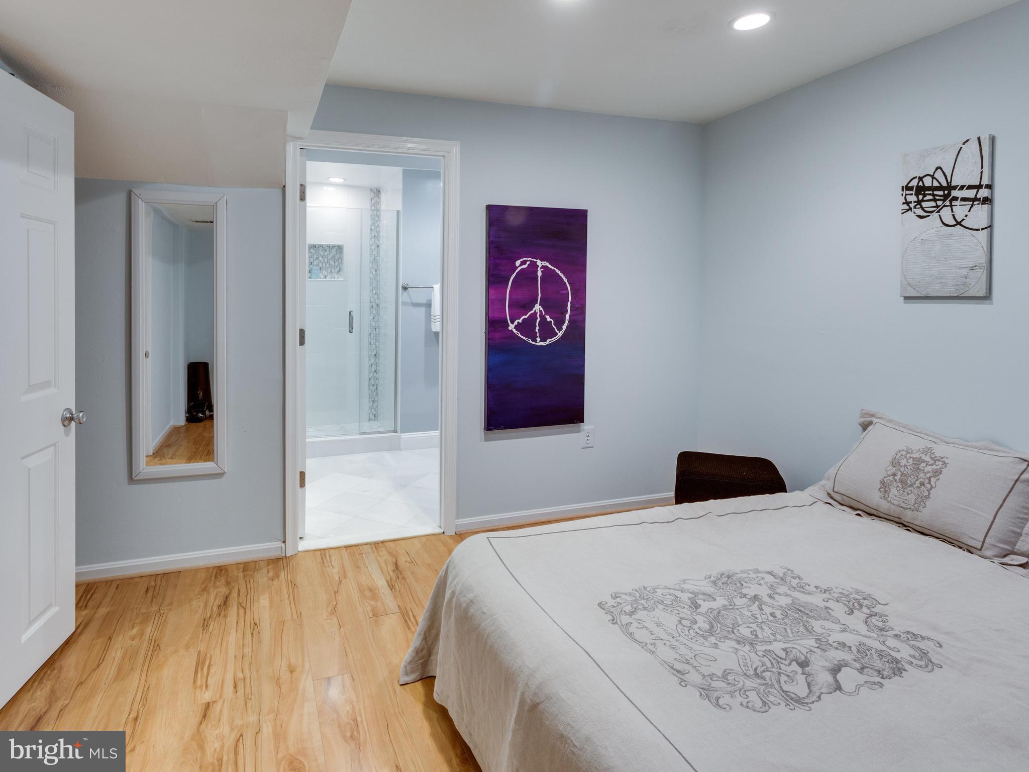 9031 Edgepark Road Vienna, VA 22182 - Photo 23 of 30 a bedroom with a large bed and a wooden floor