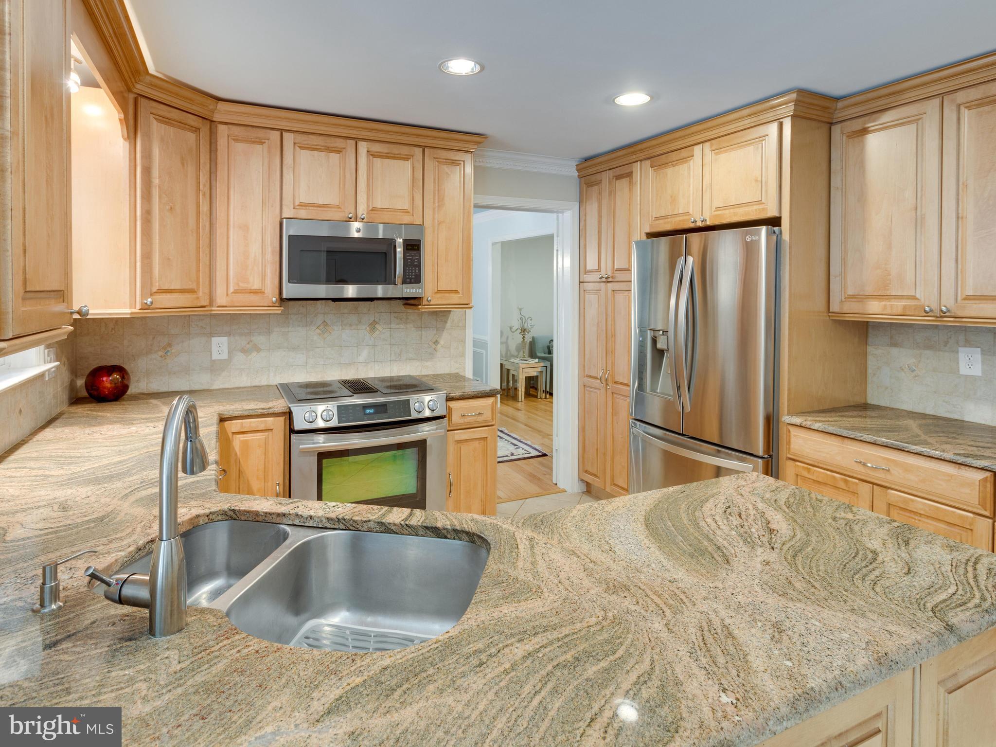 9031 Edgepark Road Vienna, VA 22182 - Photo 9 of 30 a kitchen with stainless steel appliances granite countertop a refrigerator a stove and a sink with wooden cabinets