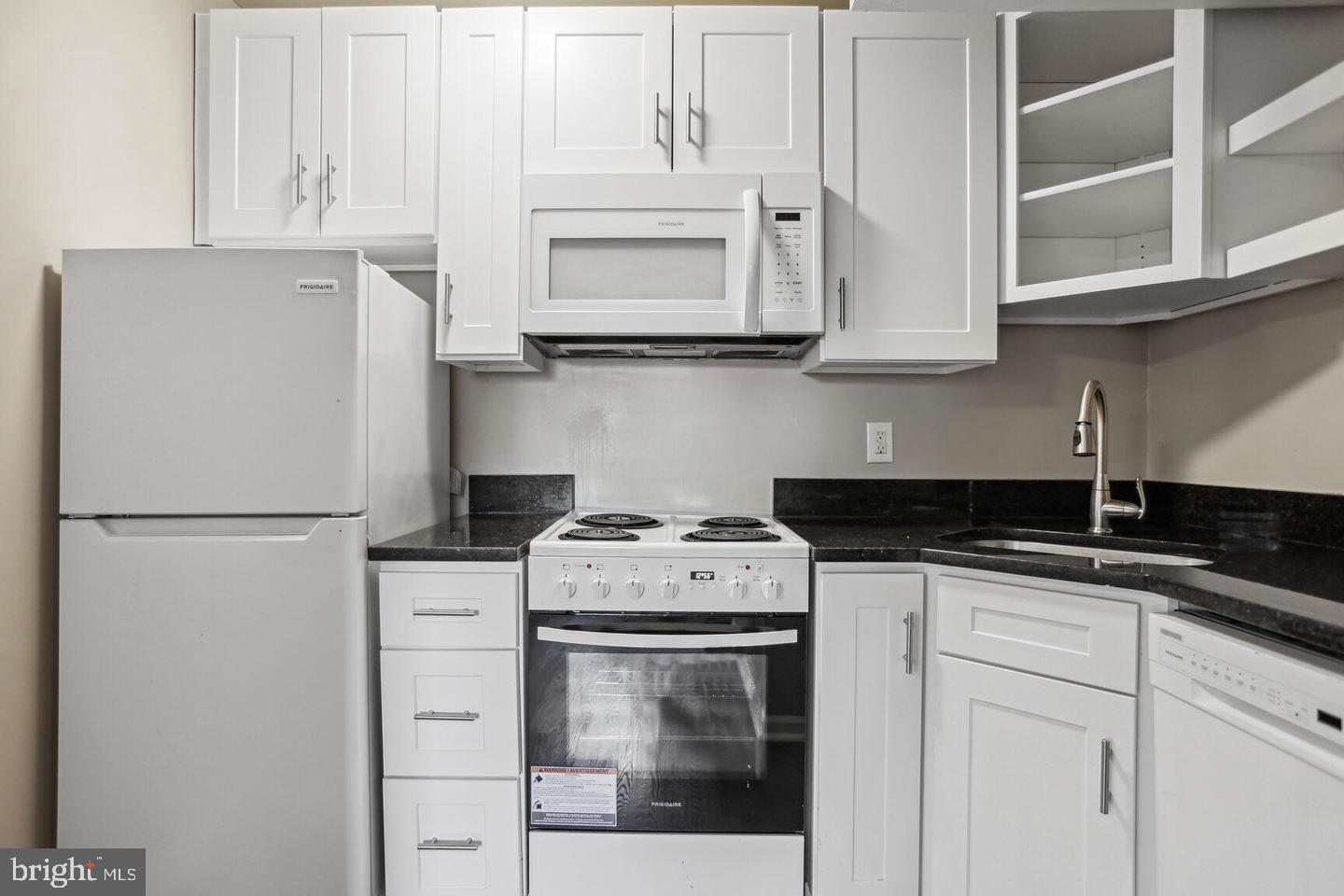 1507 Freedom Way Southeast, Unit 1 Washington, DC 20003 - Photo 5 of 15 a white kitchen with granite countertop white cabinets and stainless steel appliances