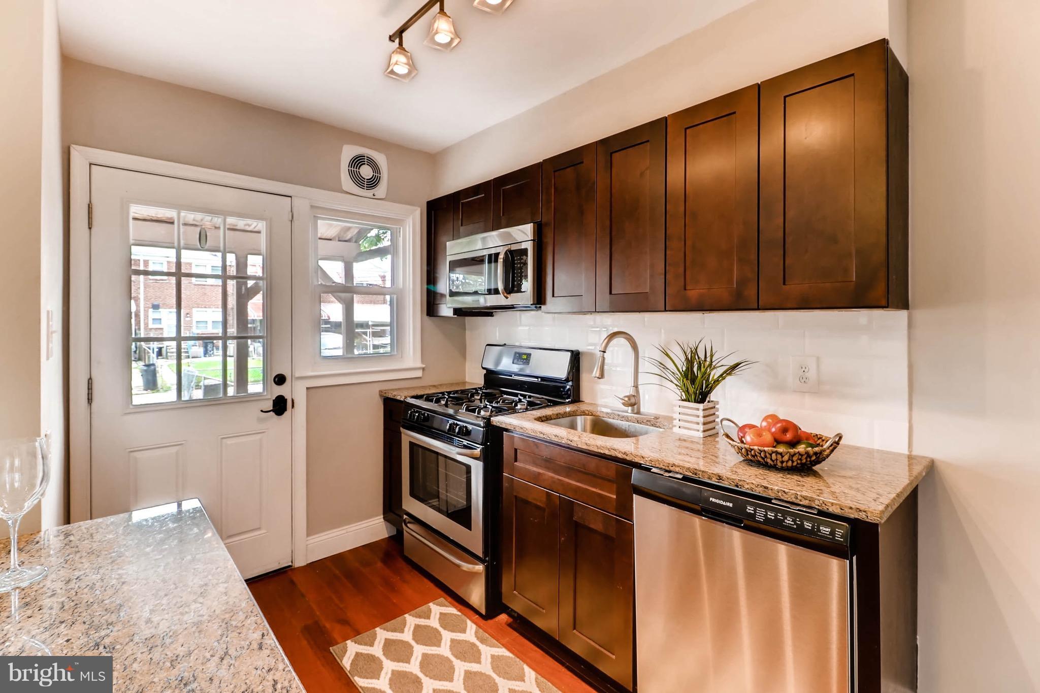 2107 Redthorn Road Baltimore, MD 21220 - Photo 5 of 14 a kitchen with stainless steel appliances granite countertop a stove sink and cabinets